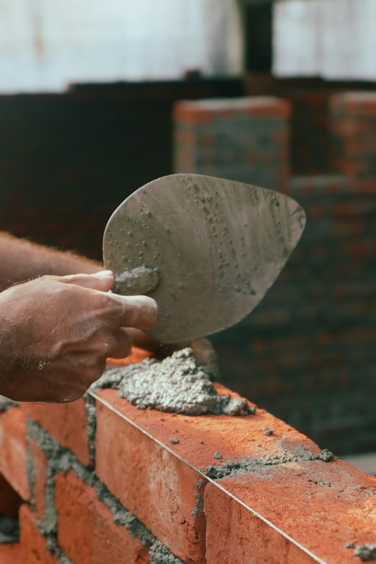 Lavori di muratura con cazzuola su muro di mattoni